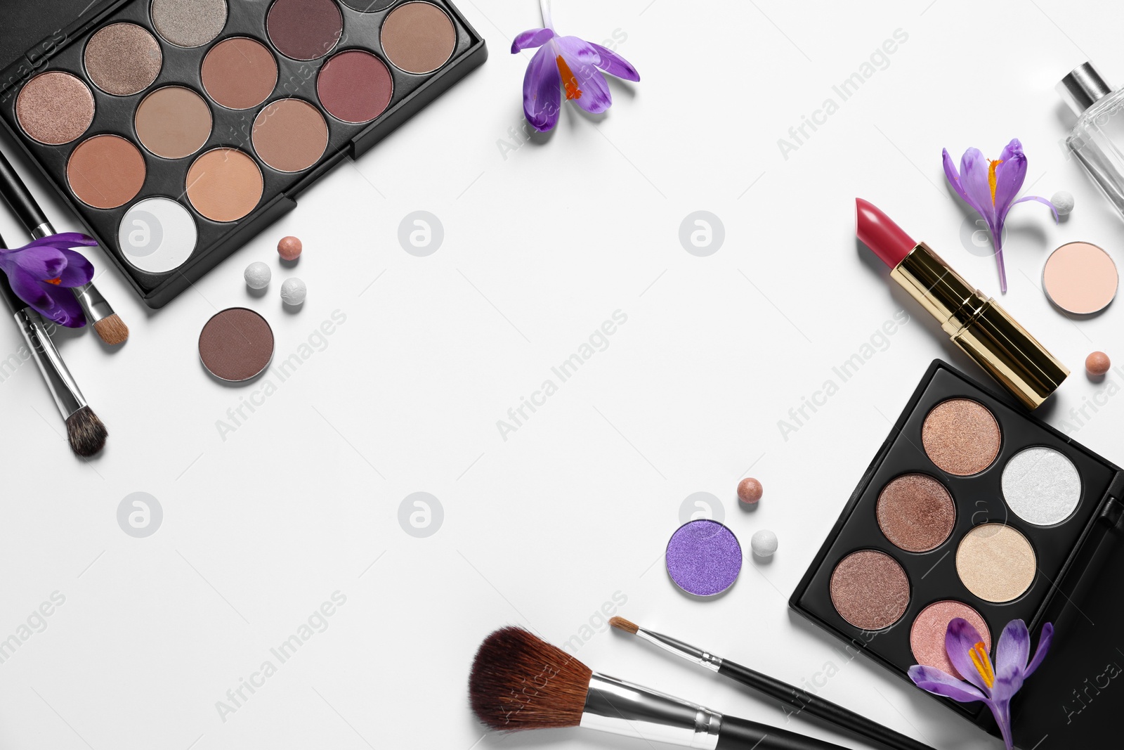 Photo of Flat lay composition with eyeshadow palettes and beautiful crocuses on white background, space for text