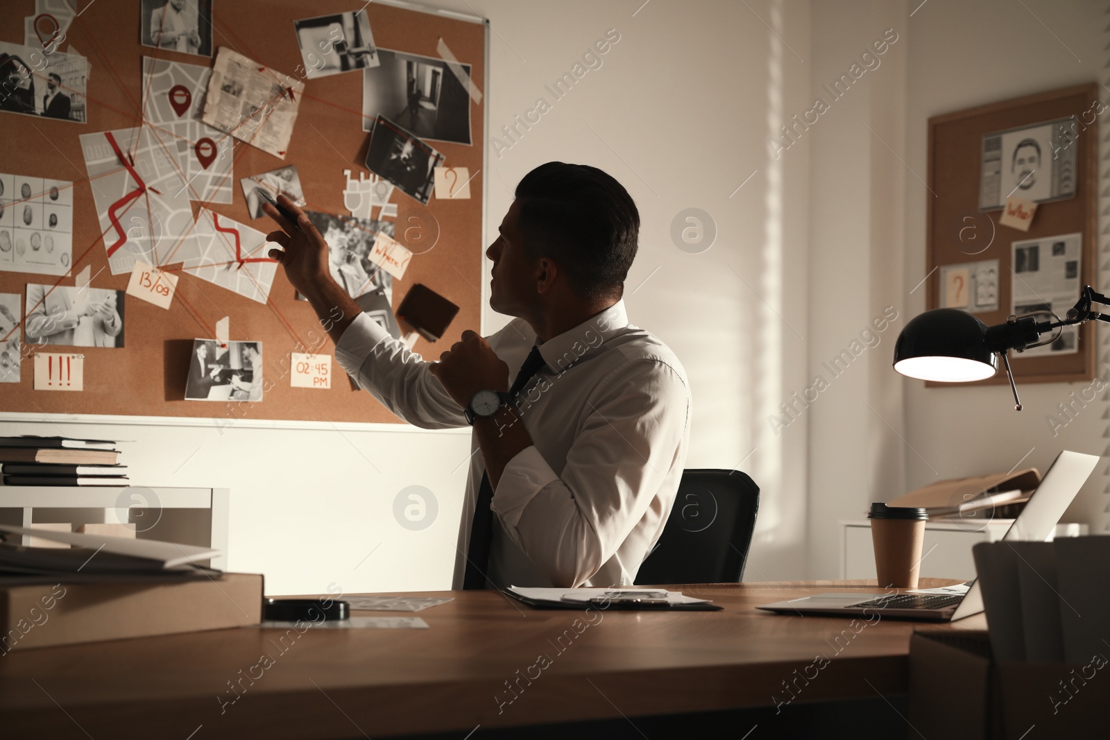 Photo of Detective looking at evidence board in office