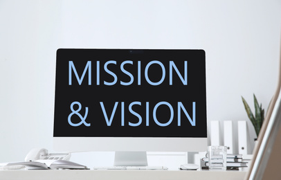 Image of Modern computer with phrase MISSION AND VISION indoors 