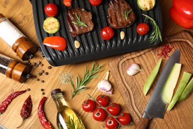 Photo of Flat lay composition with electric grill and different products on wooden table