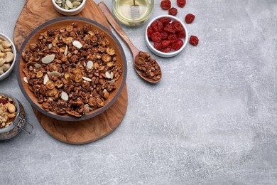 Photo of Tasty granola with nuts and dry fruits on light grey table, flat lay. Space for text