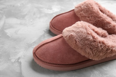 Pair of stylish soft slippers on grey background, closeup