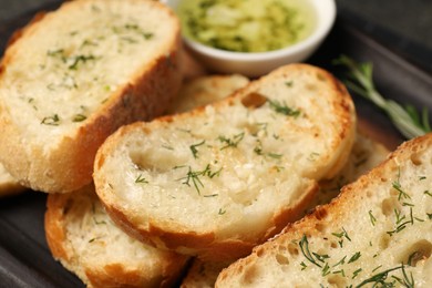 Photo of Tasty baguette with garlic and dill, closeup