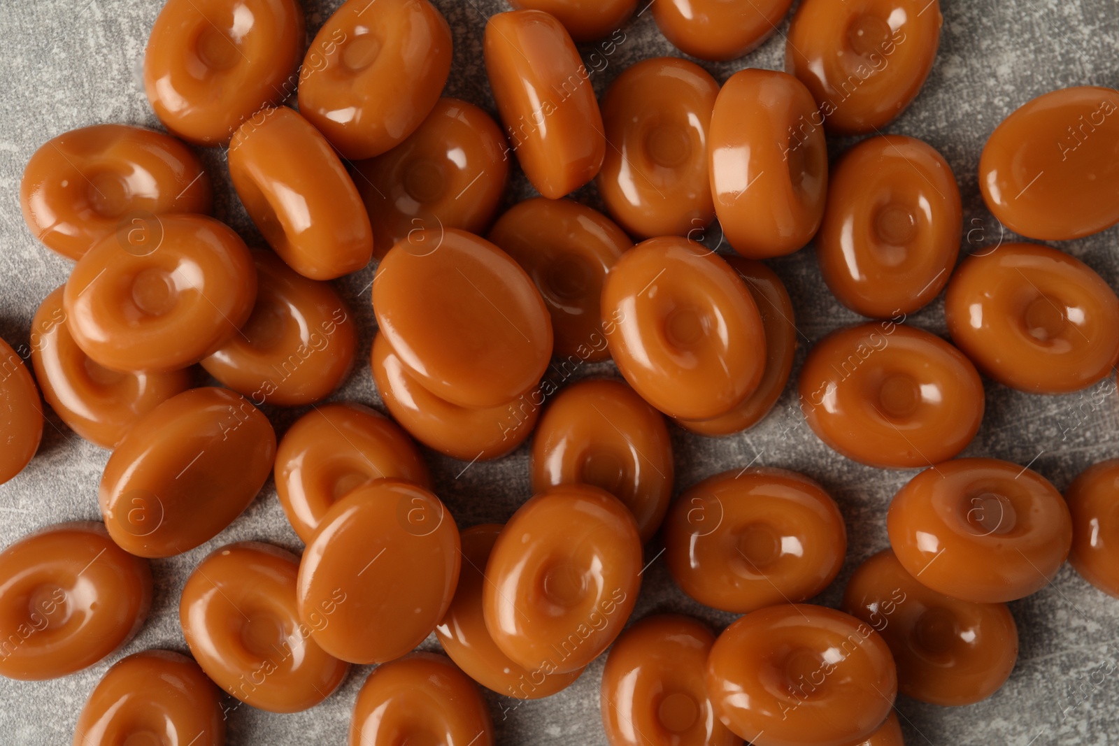 Photo of Tasty hard toffee candies on light grey table, flat lay