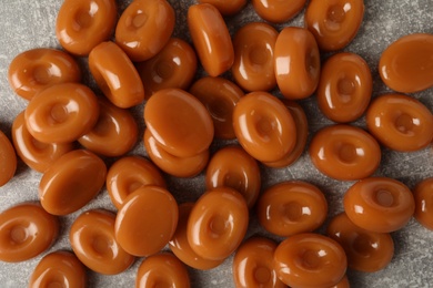 Photo of Tasty hard toffee candies on light grey table, flat lay