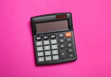 Calculator on pink background, top view. Office equipment