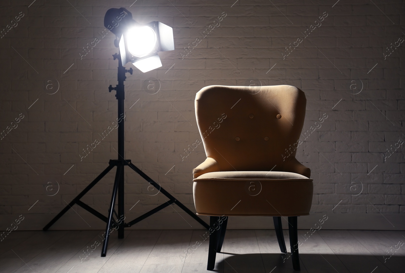 Photo of Interior of modern photo studio with professional lighting equipment and armchair