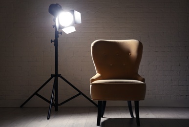 Interior of modern photo studio with professional lighting equipment and armchair