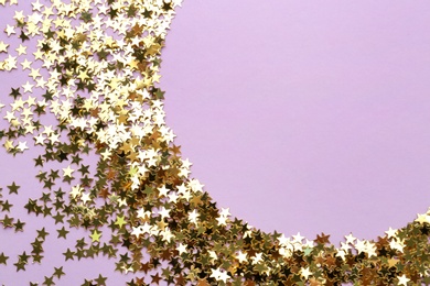 Confetti stars on violet background, flat lay with space for text. Christmas celebration