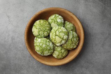 Photo of Bowl with tasty matcha cookies on grey textured table, top view