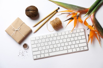 Photo of Creative flat lay composition with tropical flowers and computer keyboard on white background