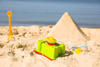 Different child plastic toys on sandy beach