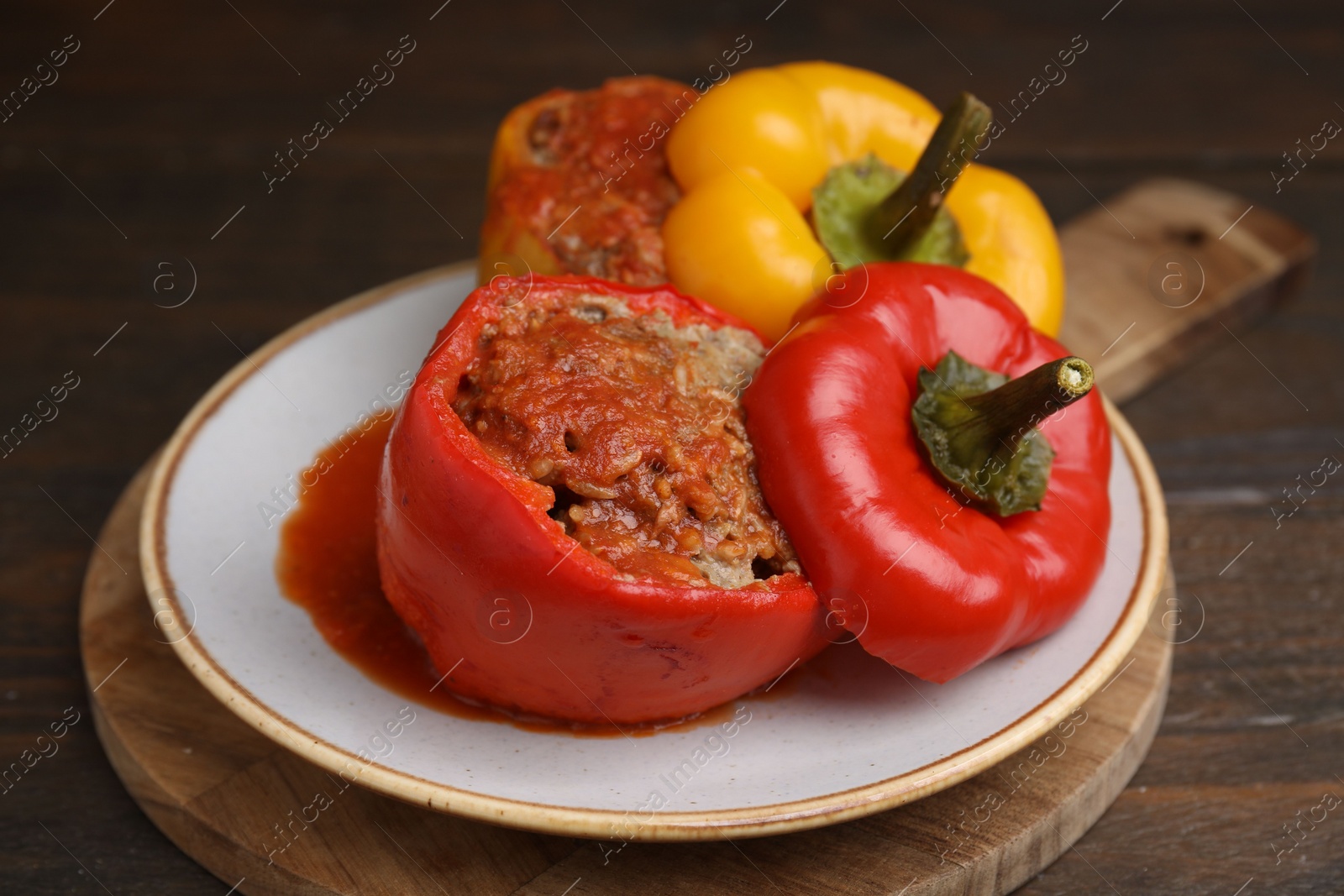 Photo of Delicious stuffed bell peppers served on wooden table