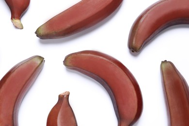 Tasty red baby bananas on white background, flat lay