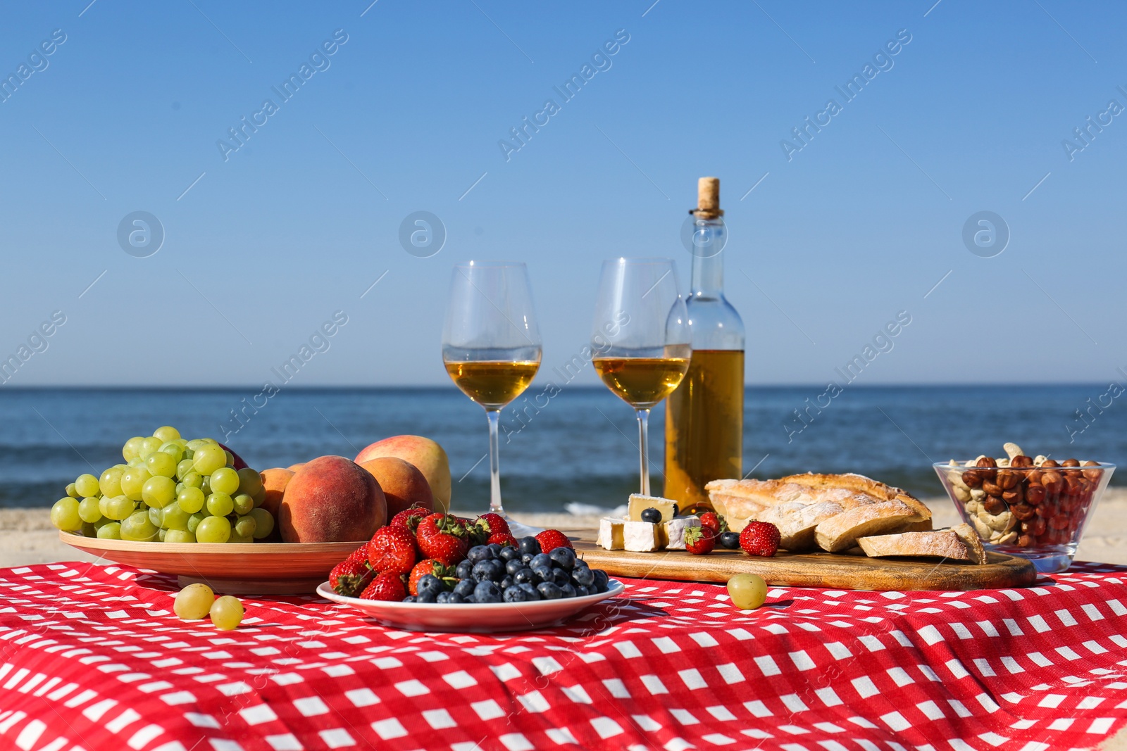 Photo of Food and wine on beach. Summer picnic