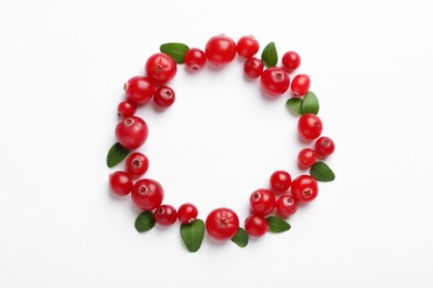 Frame made of fresh cranberries and green leaves on white background, flat lay. Space for text