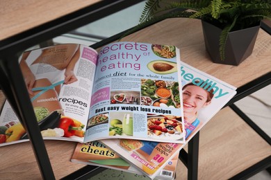 Photo of Different lifestyle magazines on shelving unit indoors