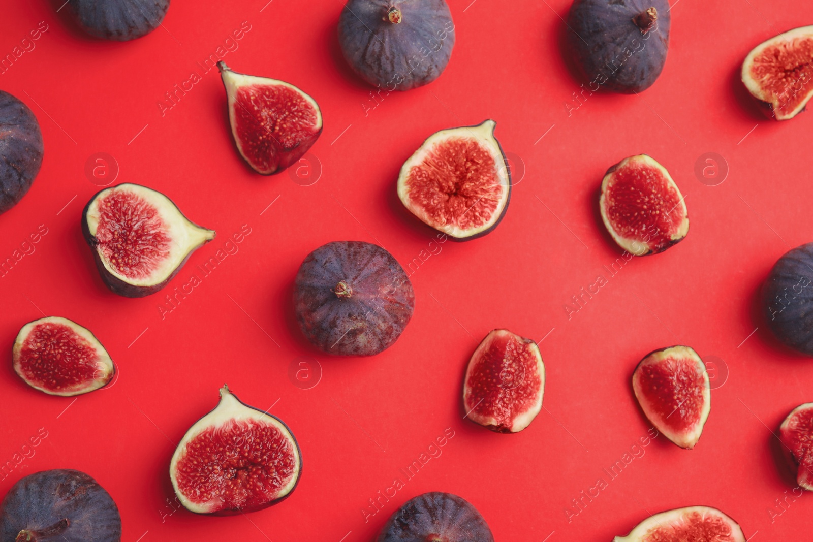 Photo of Delicious ripe figs on red background, flat lay