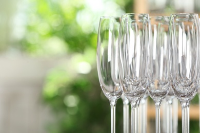 Photo of Empty glasses against blurred background, closeup. Space for text