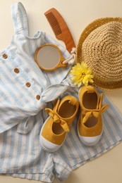 Stylish child clothes, shoes and accessories on beige background, flat lay