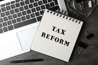 Image of Notebook with text TAX REFORM, laptop and stationery on grey table, flat lay