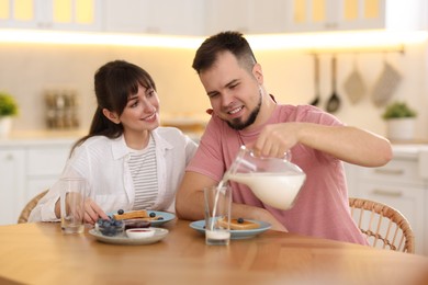 Happy couple having tasty breakfast at home