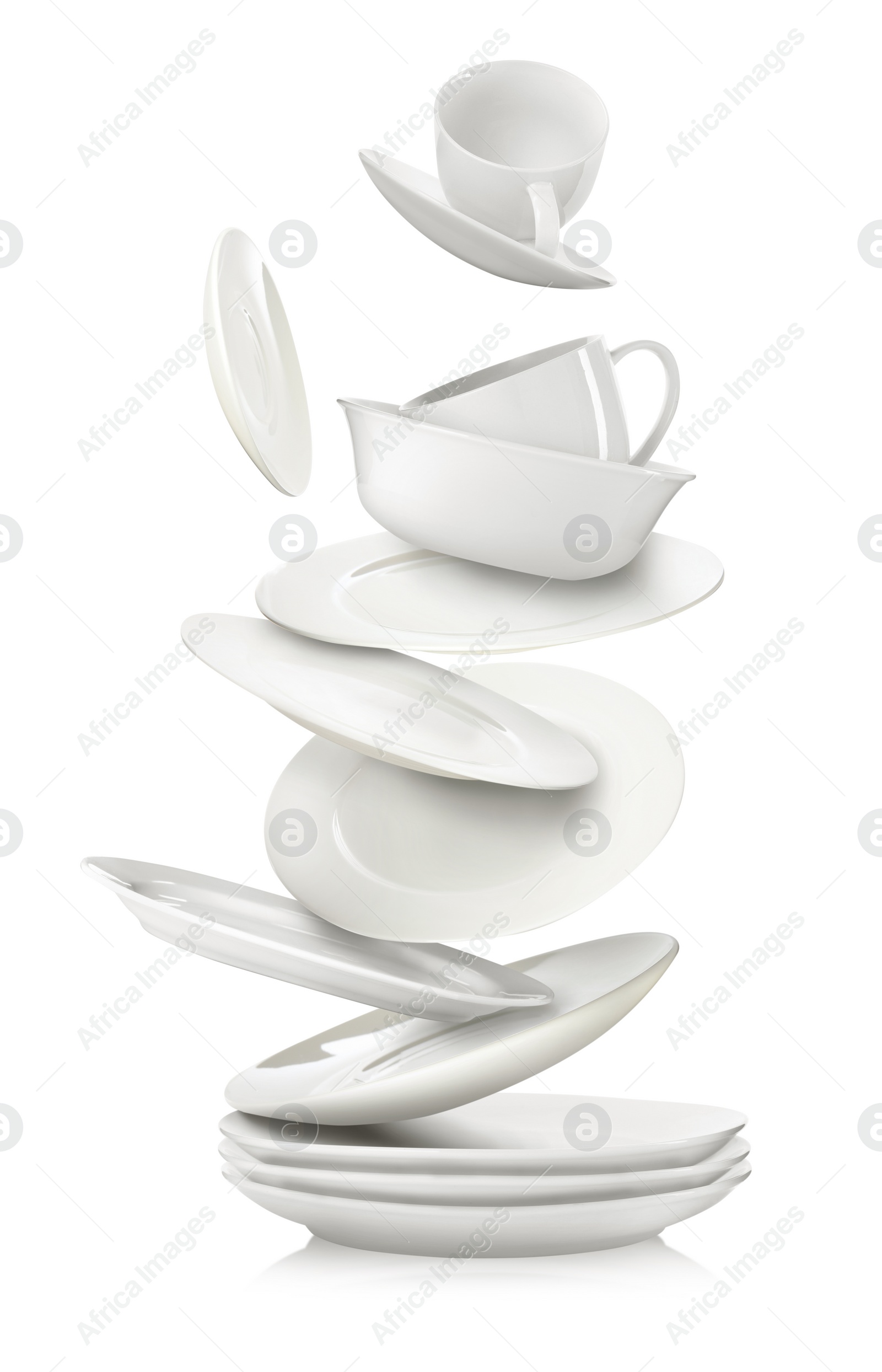 Image of Set of clean dishes and cups in flight on white background