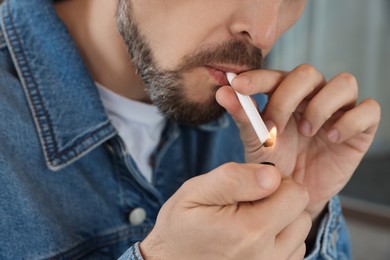 Mature man lighting cigarette outdoors, closeup of hands