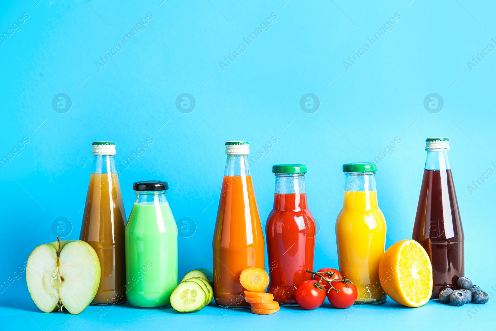 Photo of Composition with bottles of different fruit and vegetable juices on color background