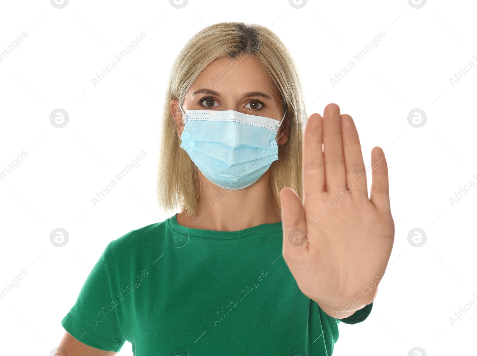 Photo of Woman in protective mask showing stop gesture on white background. Prevent spreading of coronavirus