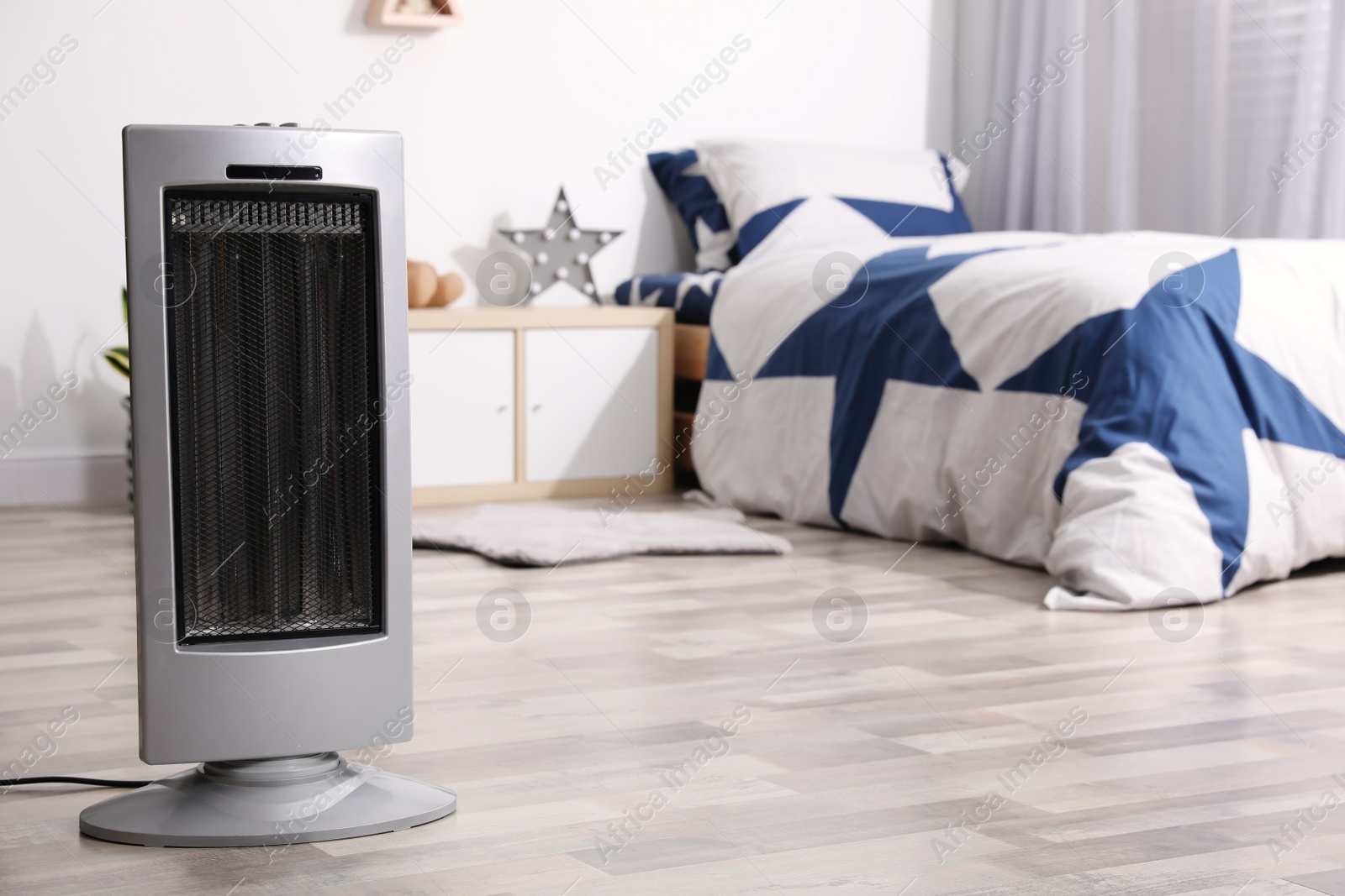 Photo of Modern electric heater on floor at home. Space for text