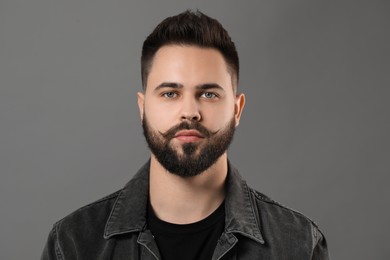 Photo of Portrait of young man with mustache on grey background