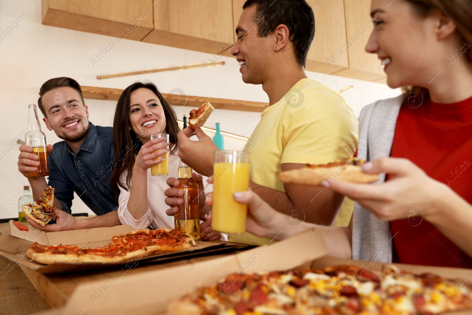 Photo of Group of friends having fun party with delicious pizza in cafe