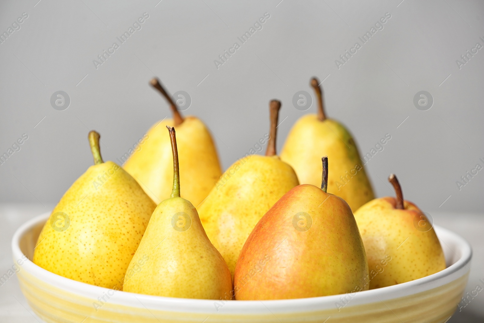 Photo of Plate with pears on grey background, closeup