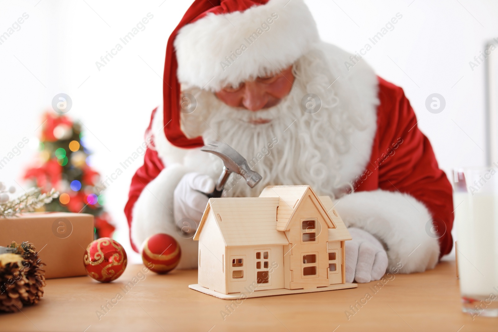 Photo of Authentic Santa Claus making toy at table in workshop