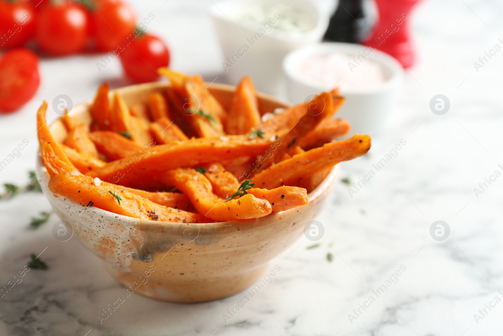 Photo of Bowl with sweet potato fries on marble table, space for text