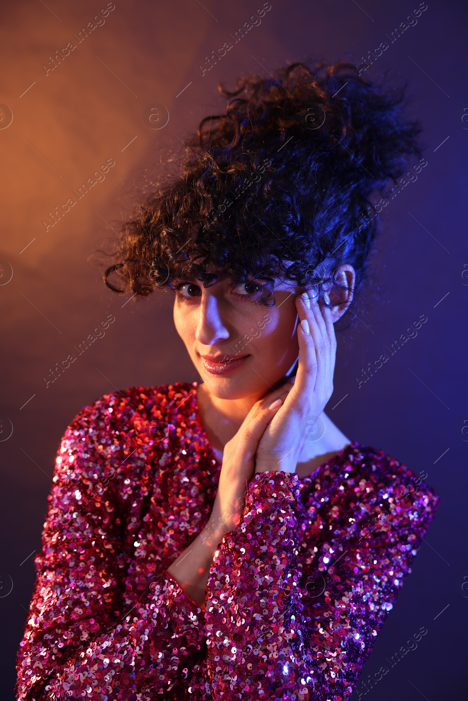 Photo of Beautiful young woman posing on color background in neon lights