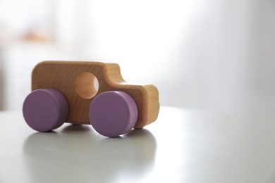 Photo of Wooden car on white table indoors. Space for text
