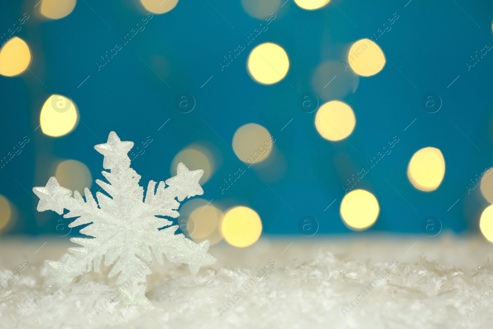 Photo of Beautiful decorative snowflake against blurred festive lights. Space for text