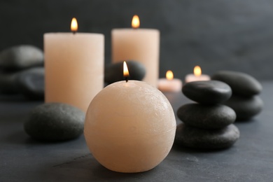 Beautiful composition with candles and spa stones on table