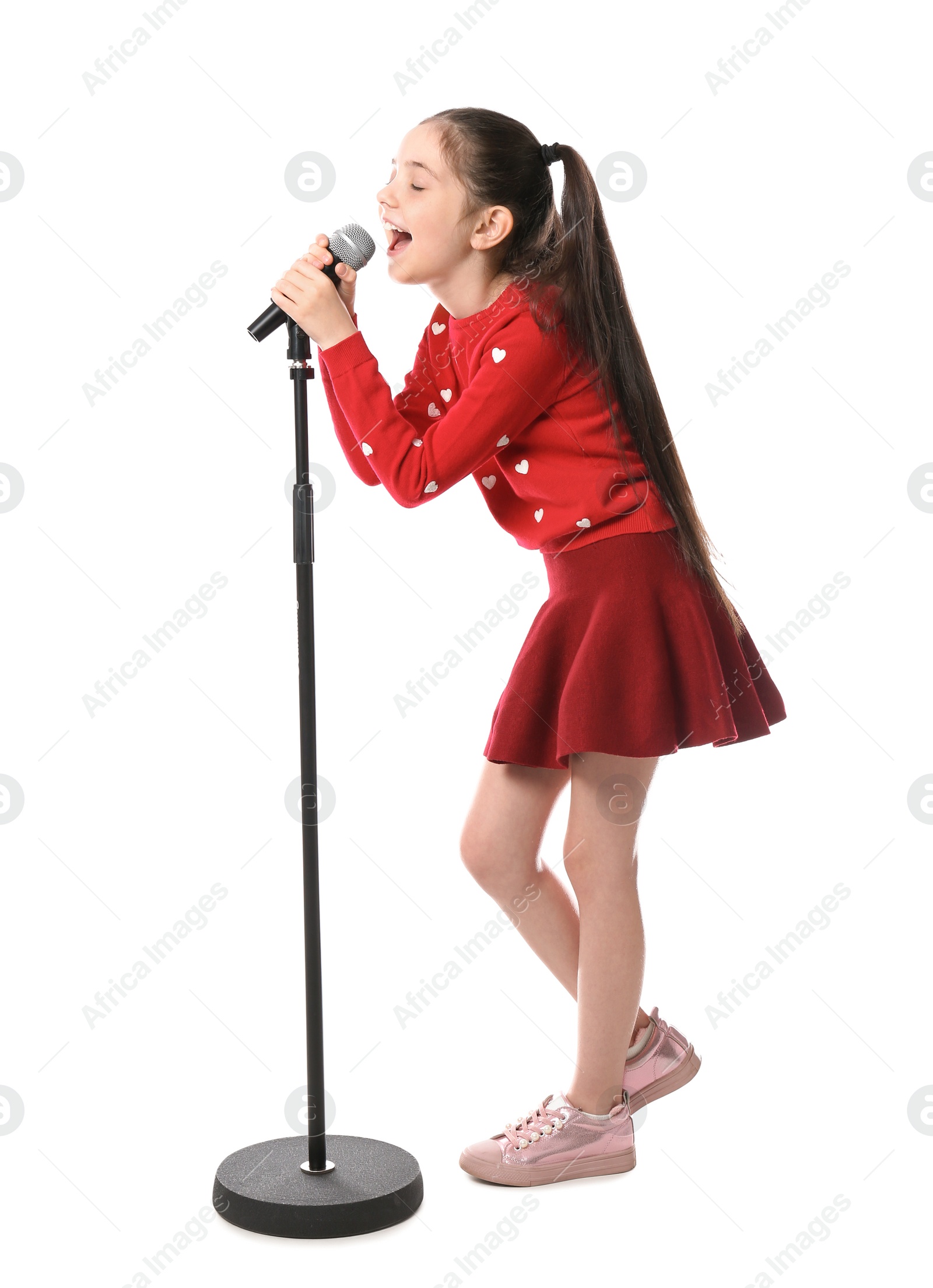 Photo of Little girl singing into microphone on white background