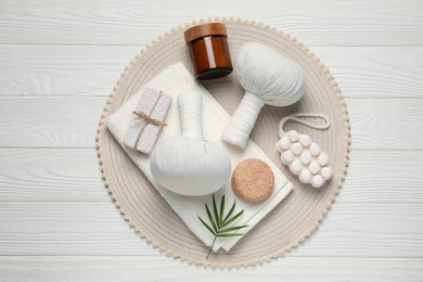 Photo of Composition of herbal bags and spa products on white wooden table, top view