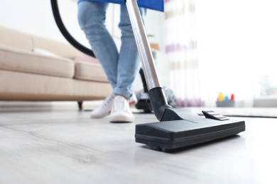 Photo of Cleaning service professional vacuuming floor with hoover, closeup
