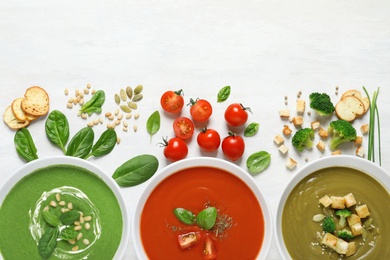 Flat lay composition with various soups and ingredients on white background. Healthy food