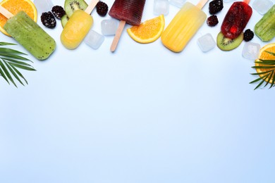 Photo of Popsicles, fresh fruits and ice cubes on light background, flat lay. Space for text