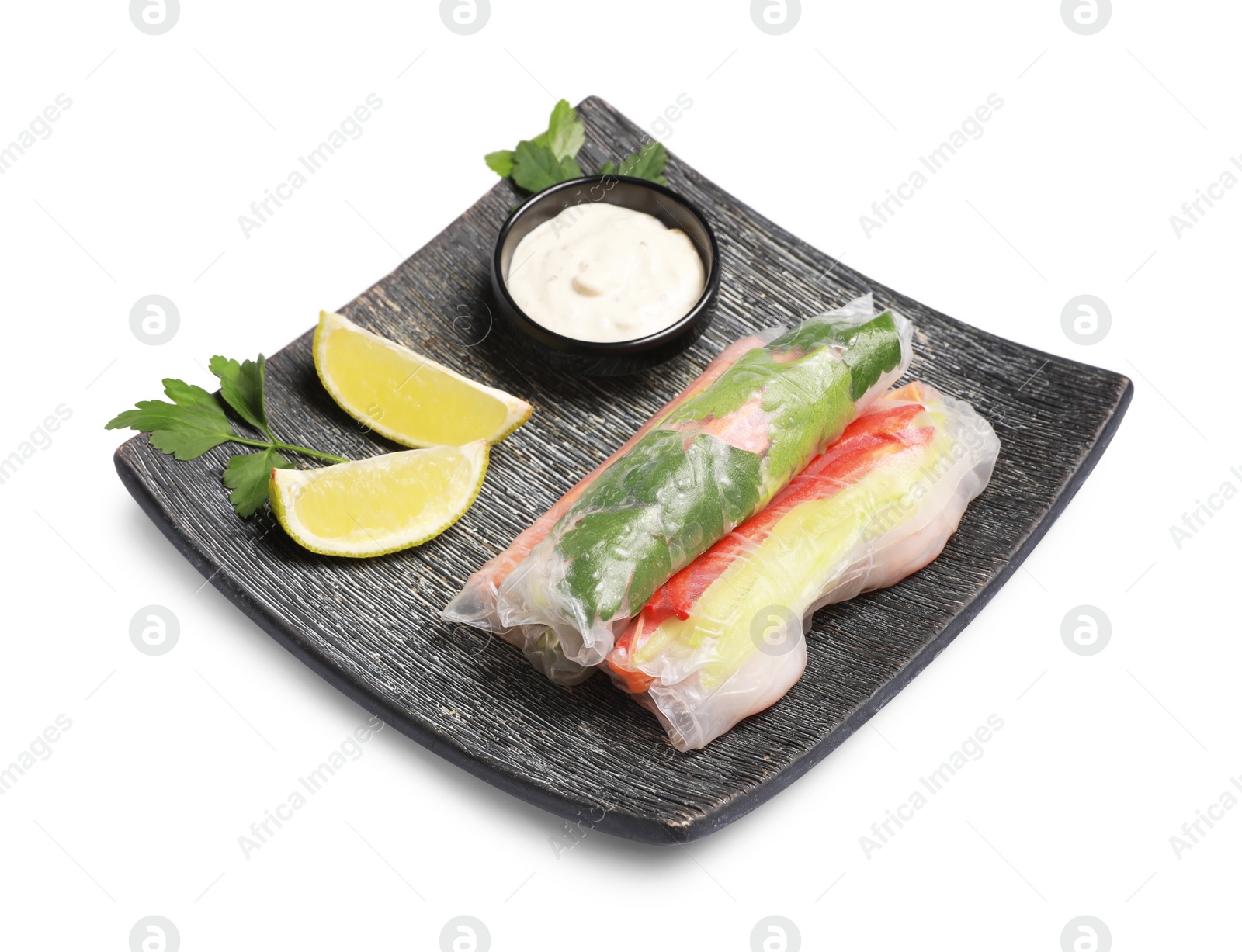 Photo of Delicious rolls wrapped in rice paper served with sauce on white background