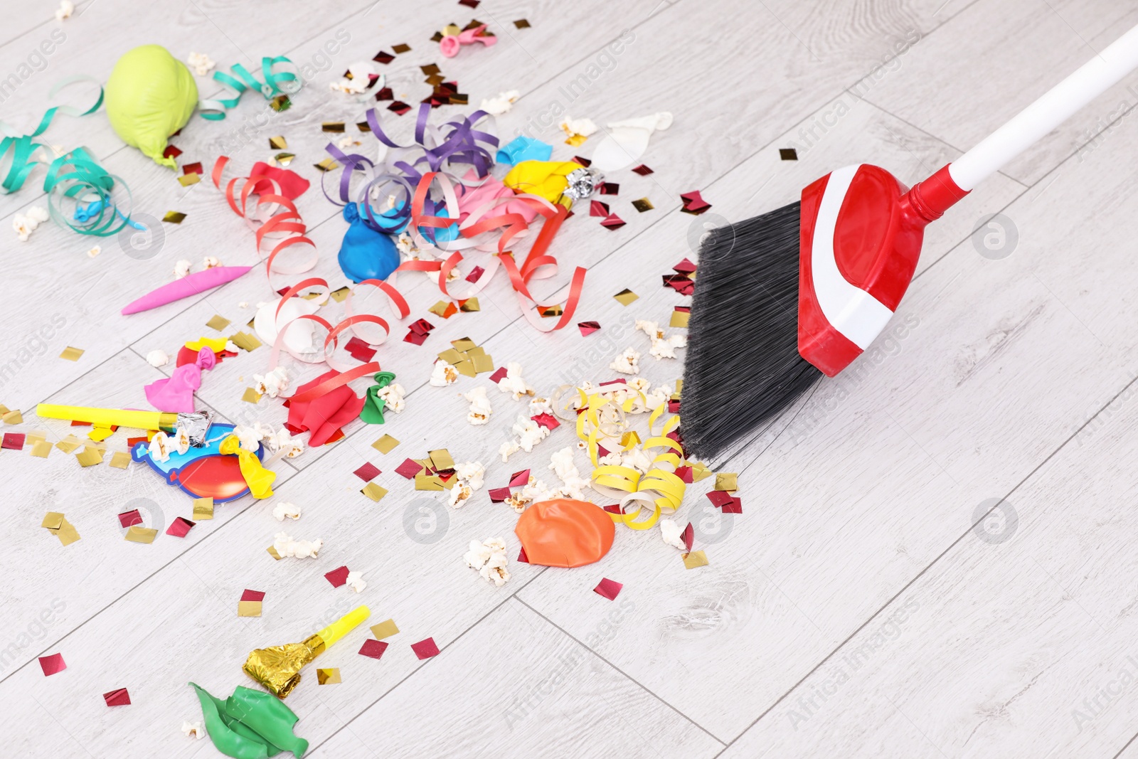 Photo of Sweeping trash after party with bristle broom indoors