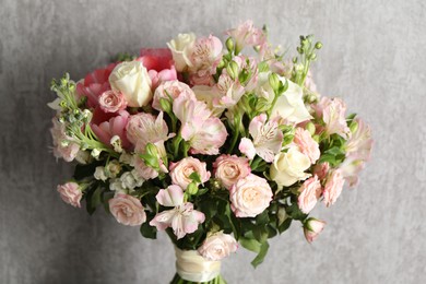 Photo of Beautiful bouquet of fresh flowers near grey wall