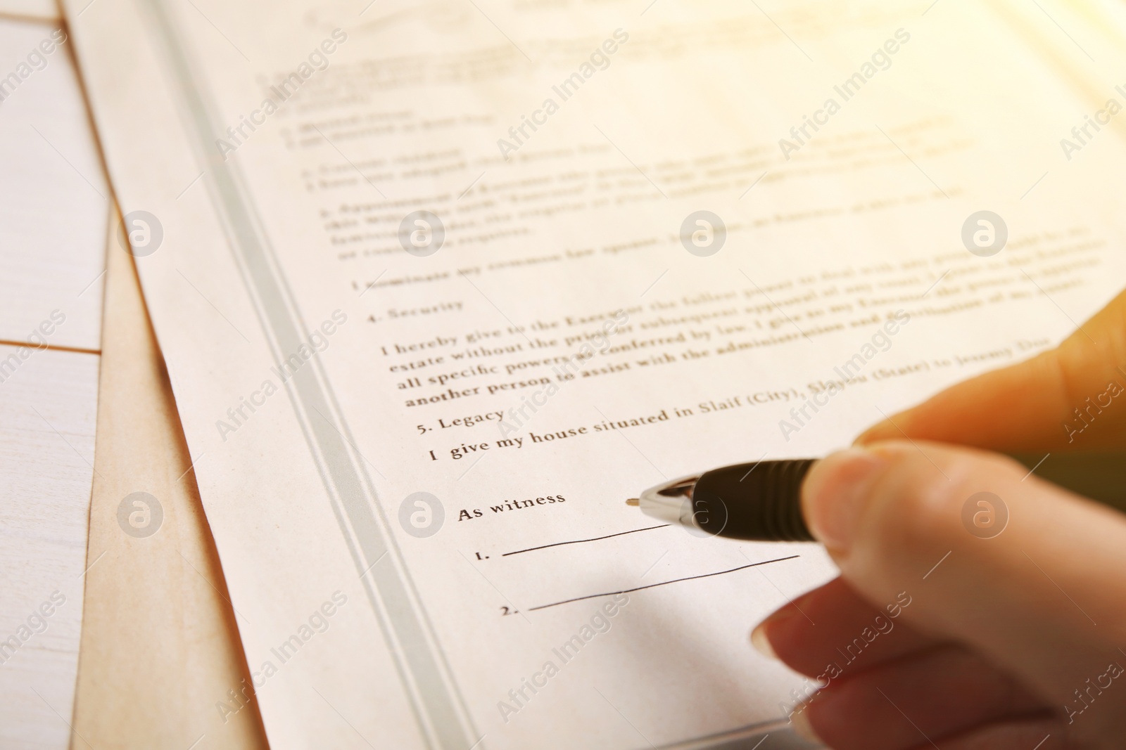 Image of Woman signing Last Will and Testament at table, closeup