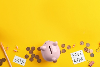 Photo of Flat lay composition with piggy bank and coins on yellow background, space for text. Money savings